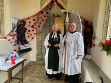 St George's Church porch decorated for Remembrance Sunday by Seven Rivers Cheshire Home, with Canon Stephen Carter and crucifer
